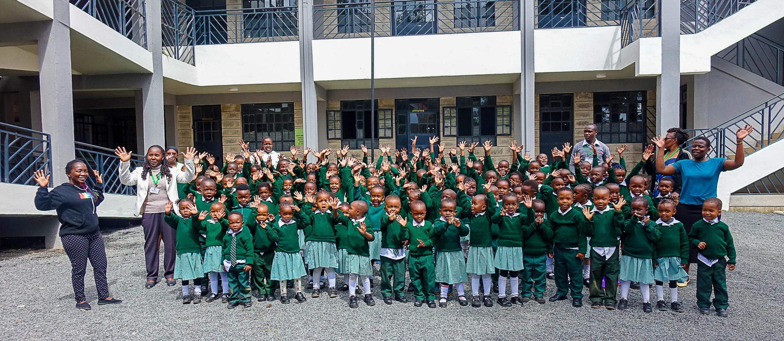 Elever i grön skoluniform framför New Life Missions nya grundskola i Ongata Rongai