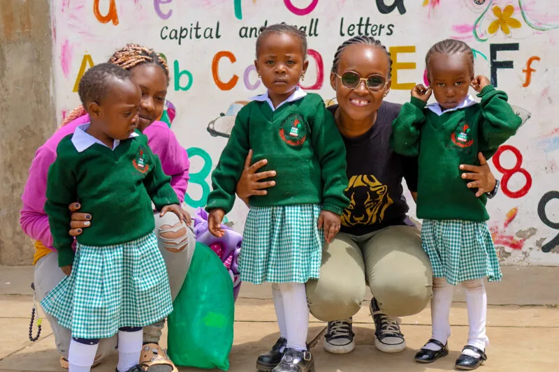 Förskolebarn i skoluniform med sin lärare – utbildning i Kenya genom New Life Mission