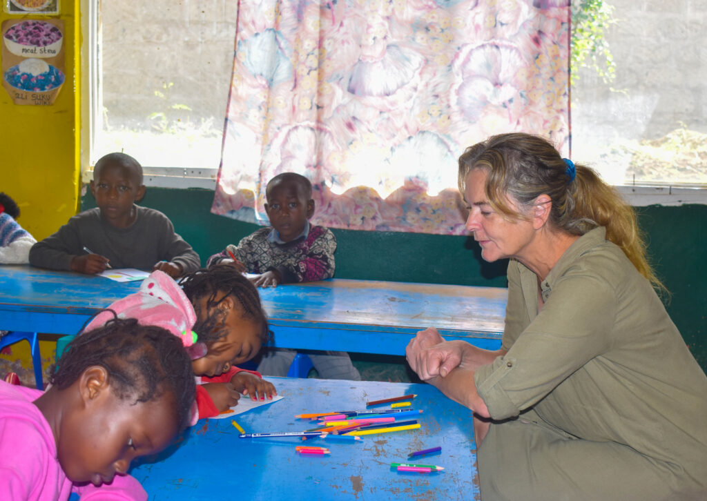 Volontär sitter tillsammans med barn i förskolan i Kenya