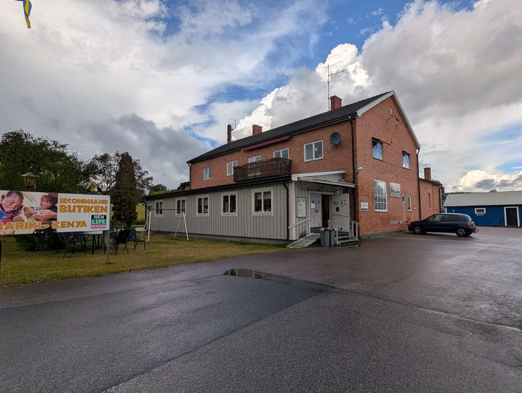 Exteriör av Secondhandbutiken Bariki med skylt och parkering